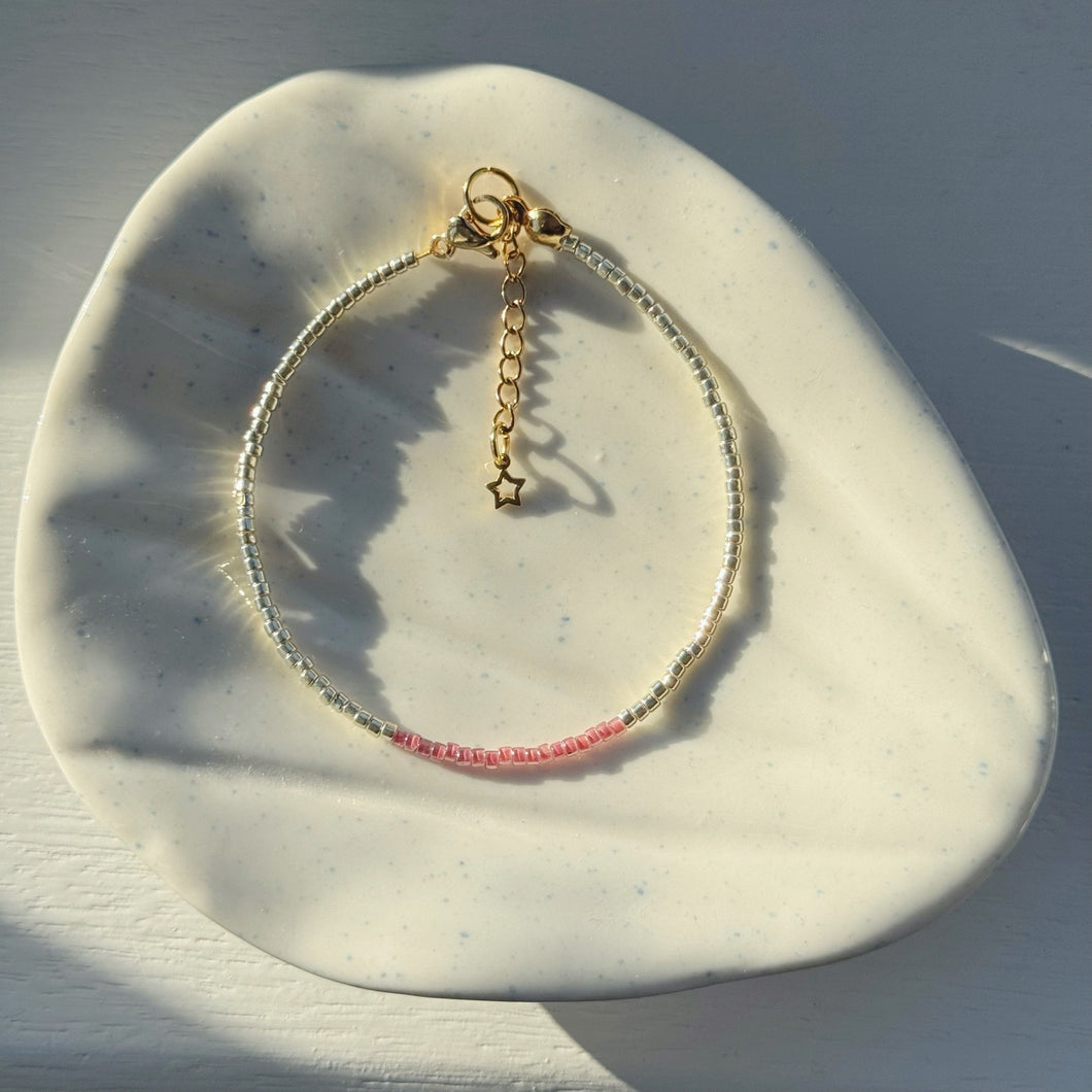 Gold bracelets with coloured accents (pinks, purples & reds)